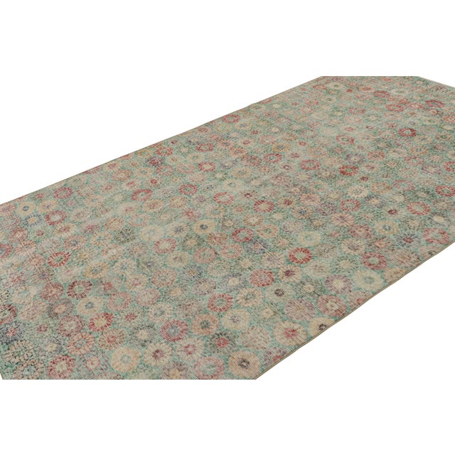 Hand Knotted in wool circa 1960-1970, this 5x10 vintage rug is believed to be a rare Zeki Múren rug, with floral patterns...