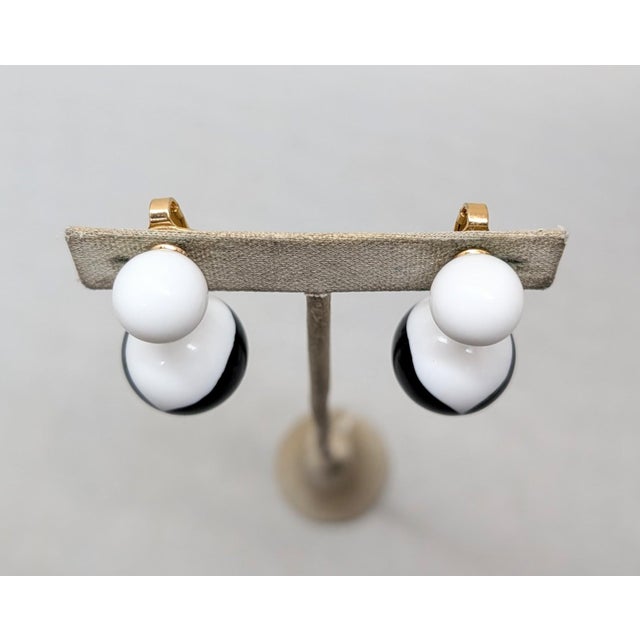 1950s goldtone white spherical resin top with black and white resin drop clip earrings. Marked "TRIFARI" with a crown over...