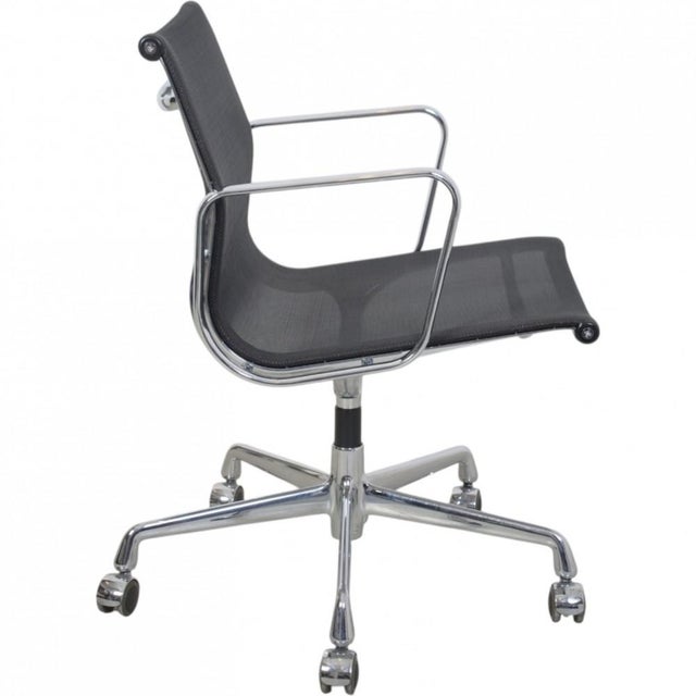 Charles Eames EA-117 office chair upholstered in black mesh, with chrome armrests and frame. The chair is from 2002 and...