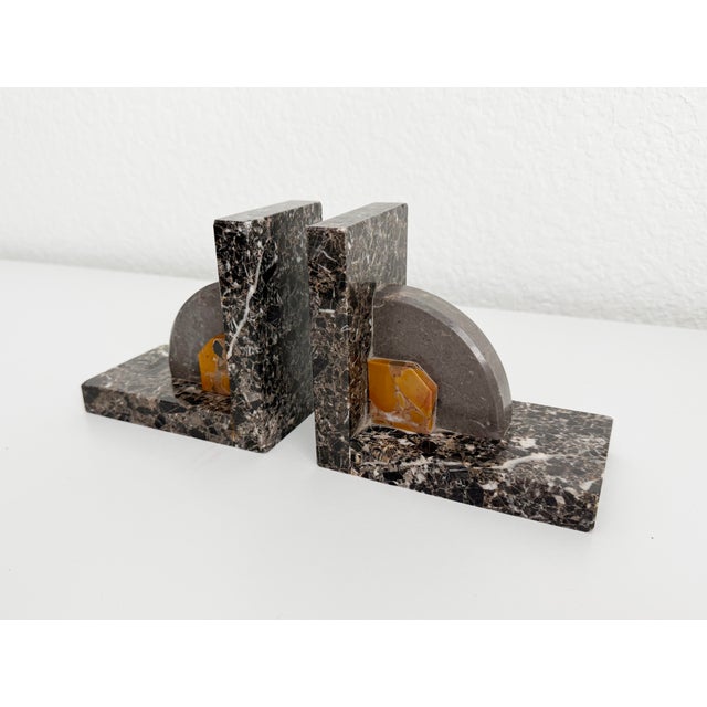 A rare pair of Art Deco stone bookends featuring a mix of three different marble types in shades of dark chocolate brown,...