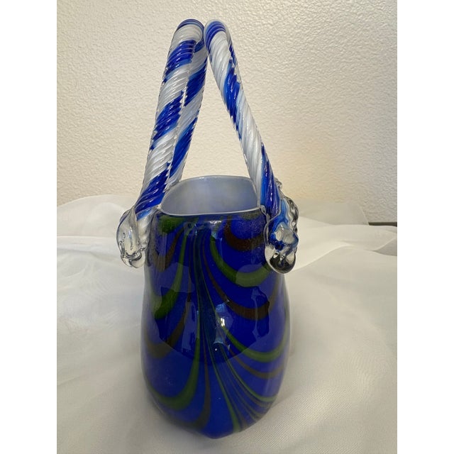 This Murano style blown art glass purse vase is a blue and green swirled body with transparent twisted candy cane style...