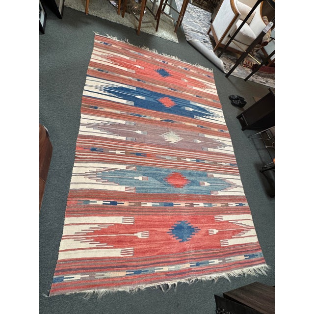 Design Plus Gallery presents a 6ft 4in × 10ft Vintage Handwoven Kilim-Style Flatweave Area Rug. This flatweave rug...