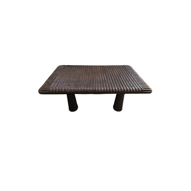 This striking coffee table is crafted from teak wood, showcasing the natural beauty of the wood's grain while featuring a...