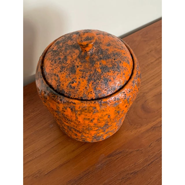 Orange textured glaze on a pot with a lid, marked "ITALY" and numbered (1385). Great color, texture, presence. As an...