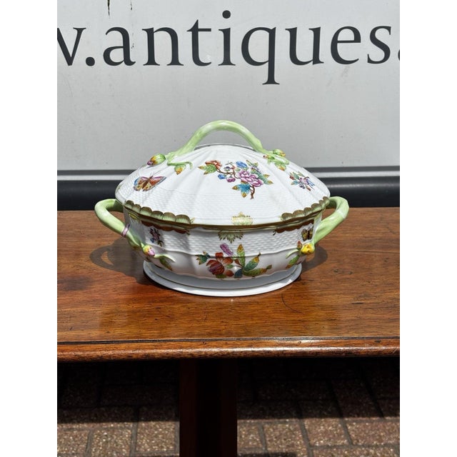 This is a Herend Queen Victoria porcelain tureen featuring a delicate branch handle and colorful painted butterflies....
