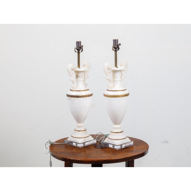 A pair of marble and bronze vase-shaped table lamps from the early 20th century, with volutes and lucite bases. Created in...