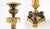 Elegant pair of French Empire-style candlesticks executed in finely chased gilt and patinated bronze. Each features a...
