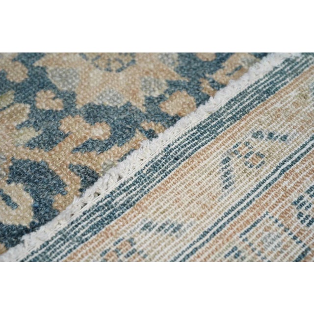 The slate blue field displays a lozengoid leaf lattice enclosing pendanted rosettes in a continuous, allover pattern....