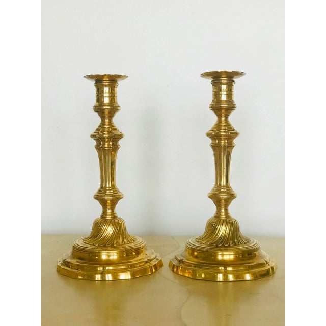 A pair of gilt bronze Louis XIV candlesticks. A fine French 18th century pair complete with bobeches.
