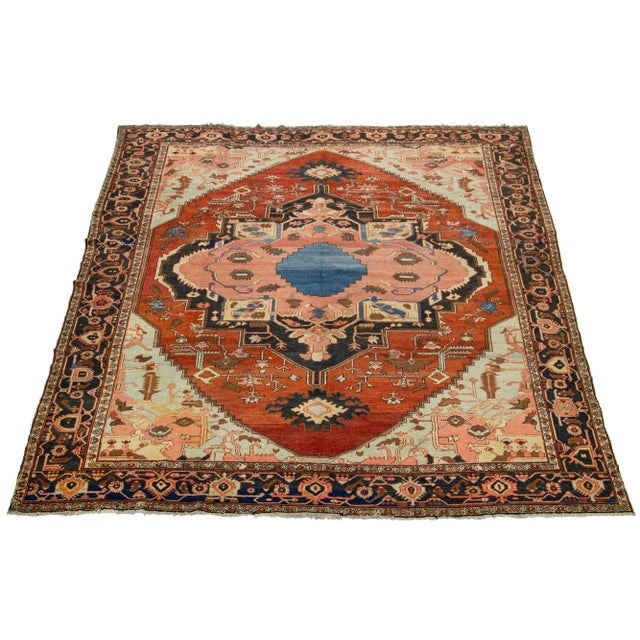 This antique Persian Serapi rug is made of hand-knotted wool. The rust field showcases a captivating medallion pattern...