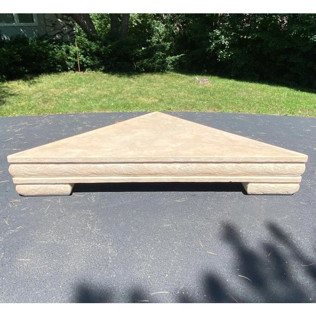 Gigantic 8.5 foot custom Postmodern triangle form plaster coffee table in a travertine style finish. This substantial...