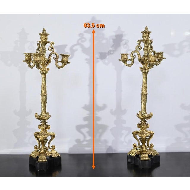 Pair of gilded bronze candelabra with four lights. Overlooked from a central candle holder with cork, on each candlestick,...