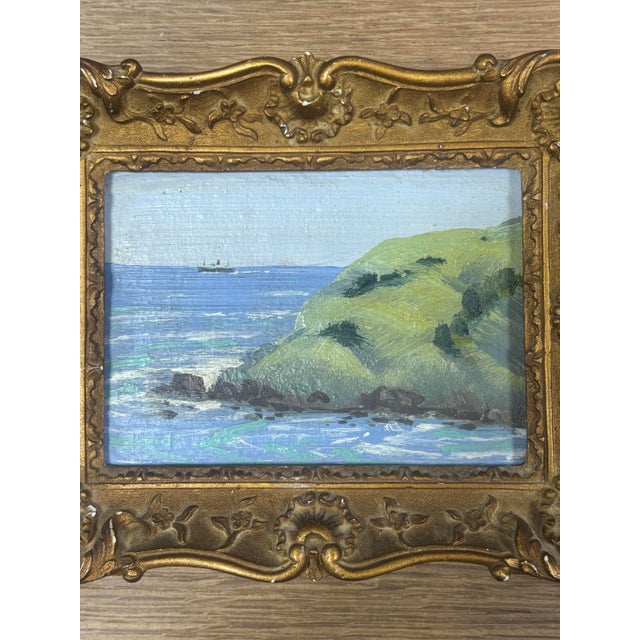 This vintage English original oil on board seascape, set within a softly aged gilt frame, captures a quiet coastal moment...