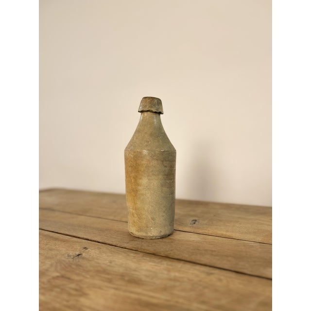 Antique glazed stoneware ginger beer bottle, dating from the 19th century. The bottle features a primitive salt-glazed...