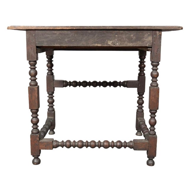 William and Mary oak tavern table. With a rectangular top with molded edge. Below with a drawer with brass bail handle....