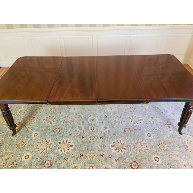 19th century English Victorian mahogany dining table with two 21” extension leaves, a thick mahogany top with a moulded...