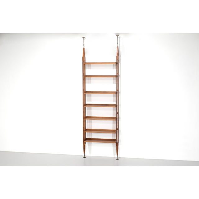 "835 Infinito" bookcase with a structure and shelves in matte Canaletto walnut, and steel hardware with a polished black...