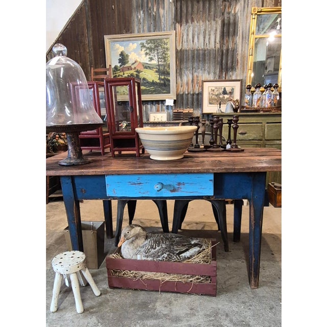 This rustic 19th-century blue painted pine table features a single drawer and a scrubbed wooden top. Circa 1860