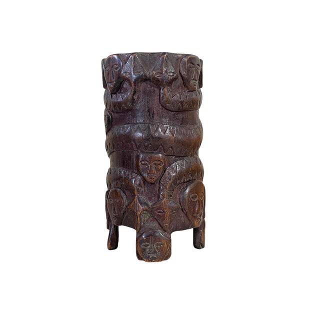This exquisite African vase, carved from a single piece of wood circa 1960, showcases high relief masks around two snakes....