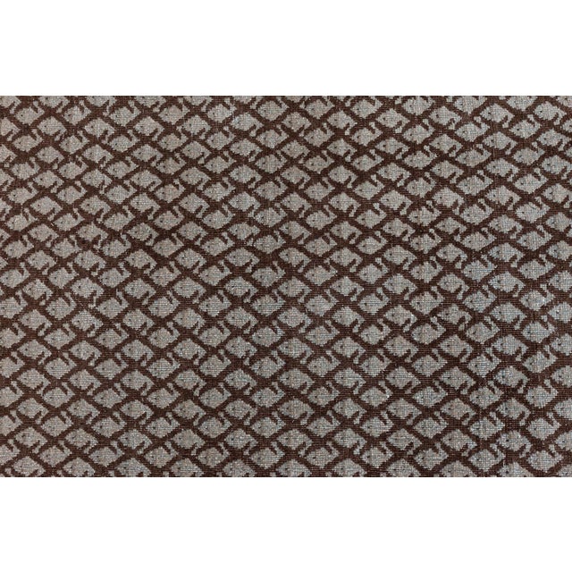 This antique Persian Tabriz rug presents a dense, all-over trellis of tiny lancet-shaped motifs in deep chocolate brown,...