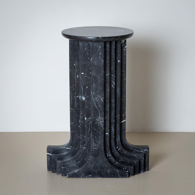 Black marble column in a stepped design with a round base. Carlo Scarpa designed this series in 1970 for the Italian...