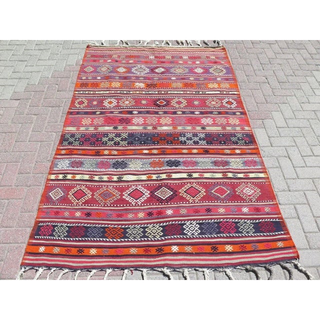 This beautiful, traditional vintage, flatweaved Turkish kilim rug is approximately 60 years old. It is handmade of very...