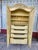 Elegant French Provincial armoire is constructed from wood with a distressed cream finish. This piece has two large doors...