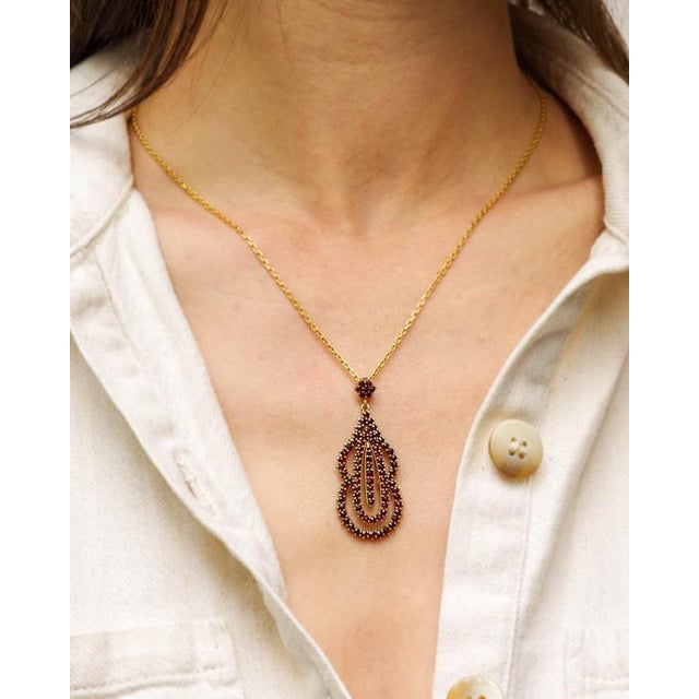 Vintage Bohemian garnet pendant in gilt silver. Drop or pear-shaped pendant, with a three-level openwork design, set with...