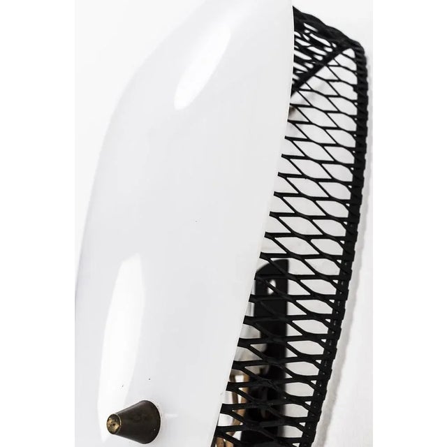 Nice 50's wall lamp with a plastic shade and a black metal grid. When the lamp is on, this grid gives a nice, subtle light...