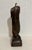 Bronze sculpture by Naomi Siegmann depicting a hanging dress decorated at the hems with geometric patterns. Piece is one...