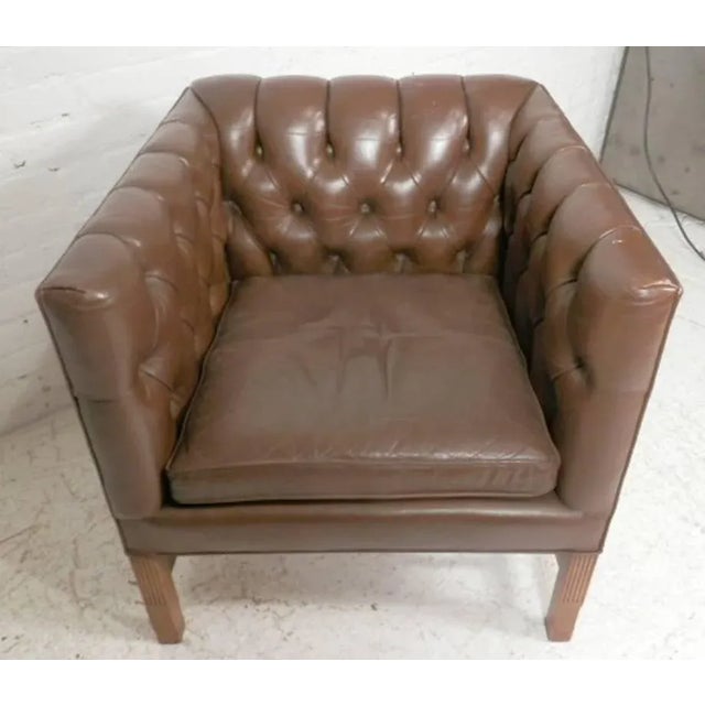Unusual shape arm chair with tufted inside back and sides. Sharp square lines, wood legs and brass nail trim. (Please...