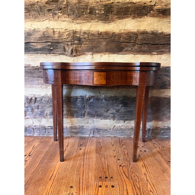 Period Federal mahogany flip-top table with Hepplewhite styling, delicate tapered legs, decorative inlay and a folding top...