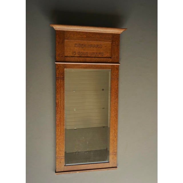 A large Dutch oak wall mirror with text in Dutch that translates as "There is no place like home". Its style is Nieuwe...