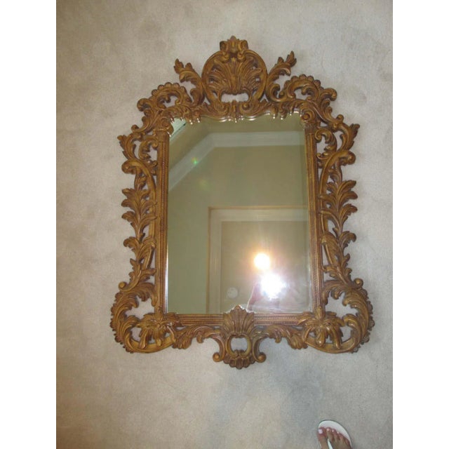 Stunning gold ornate mirror with hanging hardware attached.