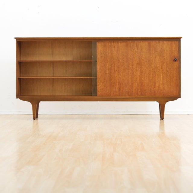 This vintage mid-century china cabinet was produced in England during the 1960s. Made from teak, this minimalist cabinet...