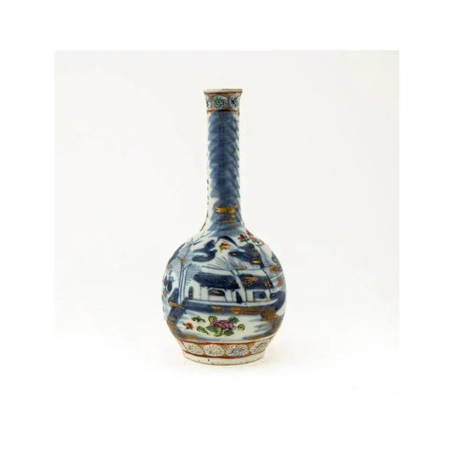 Chinese. Small famille rose bottle vase with floral, bat, and Buddhist lion decoration. Partial paper label. Approx. h....