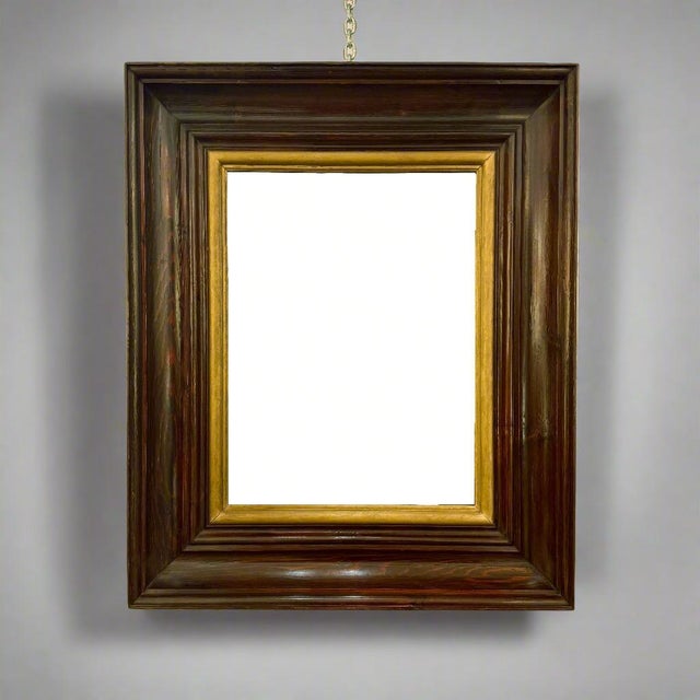 A large scale Modernist mirror in stained oak with an inner giltwood molding from France circa 1940.
