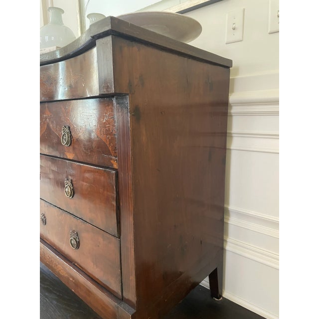 Elegant early 19th-century Biedermeier chest of drawers, featuring exquisite marquetry inlay and rich walnut veneer. The...