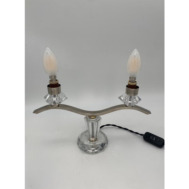 This pair of two-light table lamps features a symmetrical structure, featuring a base and decorative elements in clear...