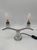 This pair of two-light table lamps features a symmetrical structure, featuring a base and decorative elements in clear...