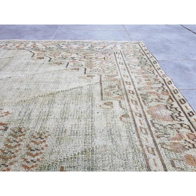 This is a vintage Turkish Oushak rug from the 1960s. The piece was hand-knotted.