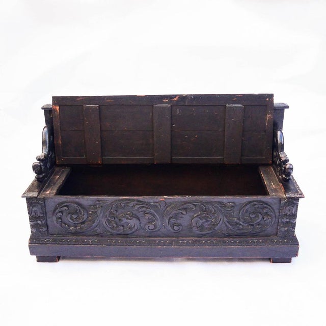 An antique rectangular carved oak bench-chest, resting on a slightly raised solid base, made in the 19th century in the...