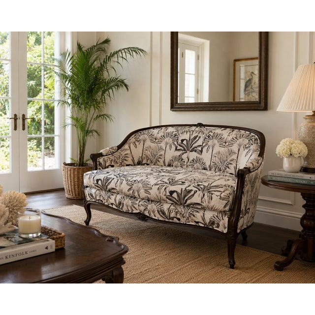 An exceptionally charming French Louis XV style settee with graceful curves, richly carved walnut framing, and fresh...