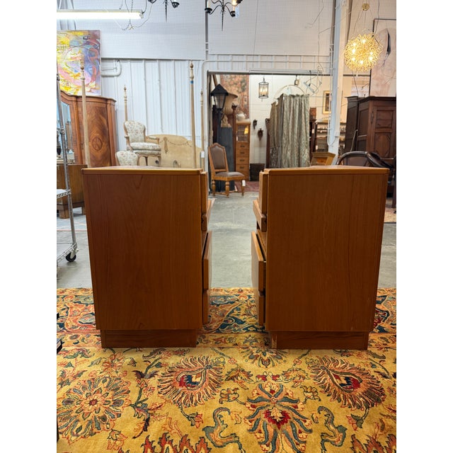 This matching pair of 1970s Danish modern teak nightstands was manufactured by Scan Coll. They feature a striking,...