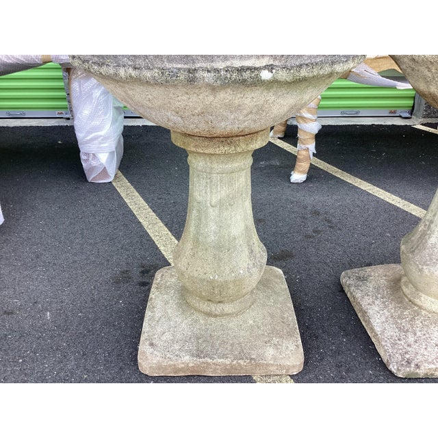 Fantastic pair of large French antique garden urns. Circa 1950, these outdoor urns feature wide scalloped tops over a...
