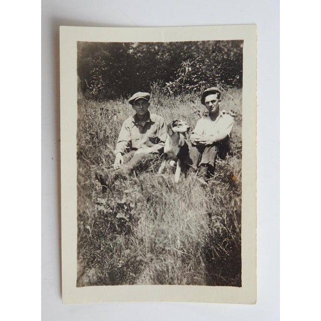 Early 20th century silver gelatin snapshot photograph of a couple working men and their hound dog. Unframed.