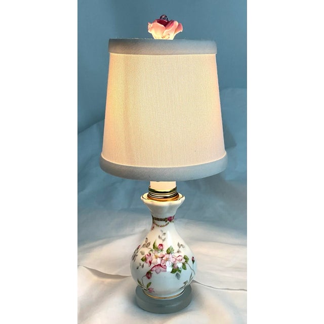 A charming accent piece that embodies timeless elegance, this vintage porcelain table lamp features a delicate hand-...