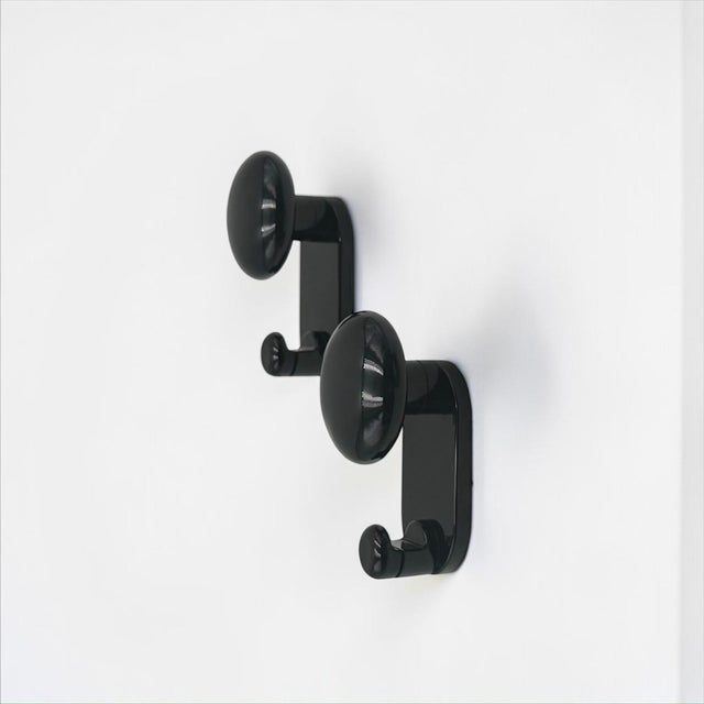 A set of two original wall hooks designed by c. Bartoli for con & con in italy during the 1970s. produced in glossy black...