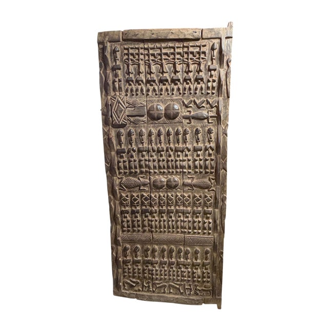 This vintage Dogon granary door from Mali features intricate carved relief figures— standing Nommo ancestors , crocodiles...