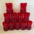 A striking set of eleven vintage ruby red art glass tumblers featuring a sculptural waisted silhouette that feels equally...